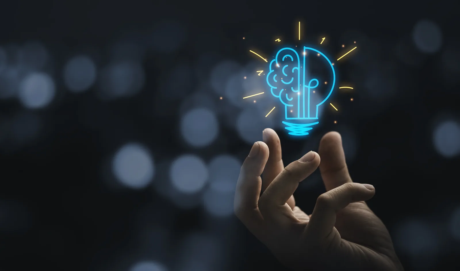 Hand holding a glowing lightbulb shaped like a brain